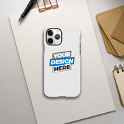Glossy iPhone tough case on a desk with customizable design option. Dual-layer protection and wireless charging friendly.
