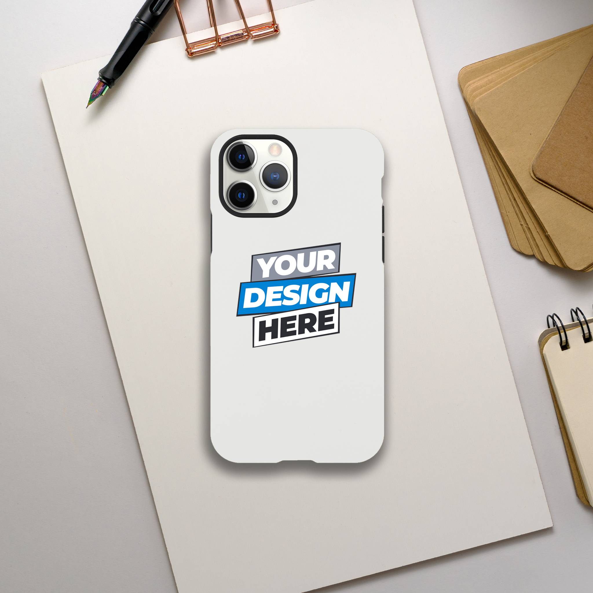 Glossy iPhone tough case on a desk with customizable design option. Dual-layer protection and wireless charging friendly.