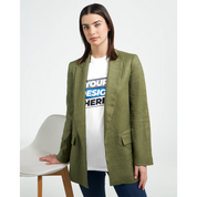 Woman wearing green blazer over typographic t-shirt, standing next to a chair.