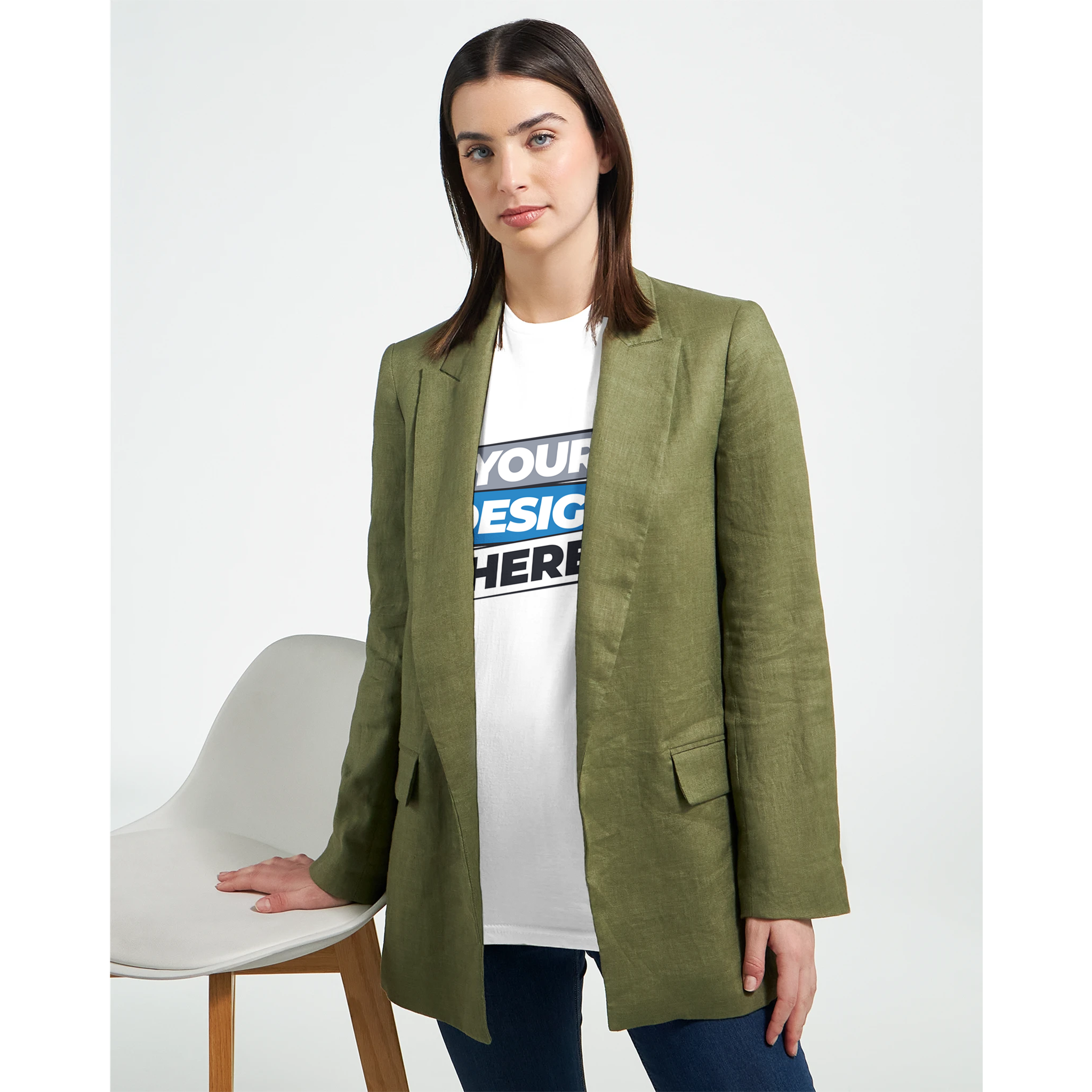 Woman wearing green blazer over typographic t-shirt, standing next to a chair.