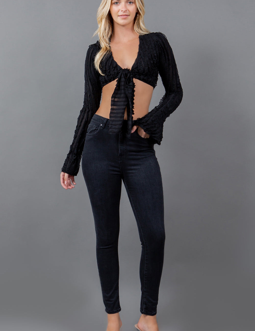 Alurien Ruffle Tie Top with flared sleeves and deep V-neckline, modeled against a gray background.