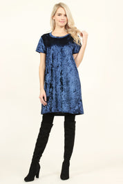 Model wearing a navy Calyn Crushed Velvet Tunic Dress with over-the-knee black boots, showcasing luxurious and versatile style.