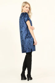 Model wearing Calyn Crushed Velvet Tunic Dress in navy with black over-the-knee boots, showcasing 32-inch relaxed fit and short sleeves.