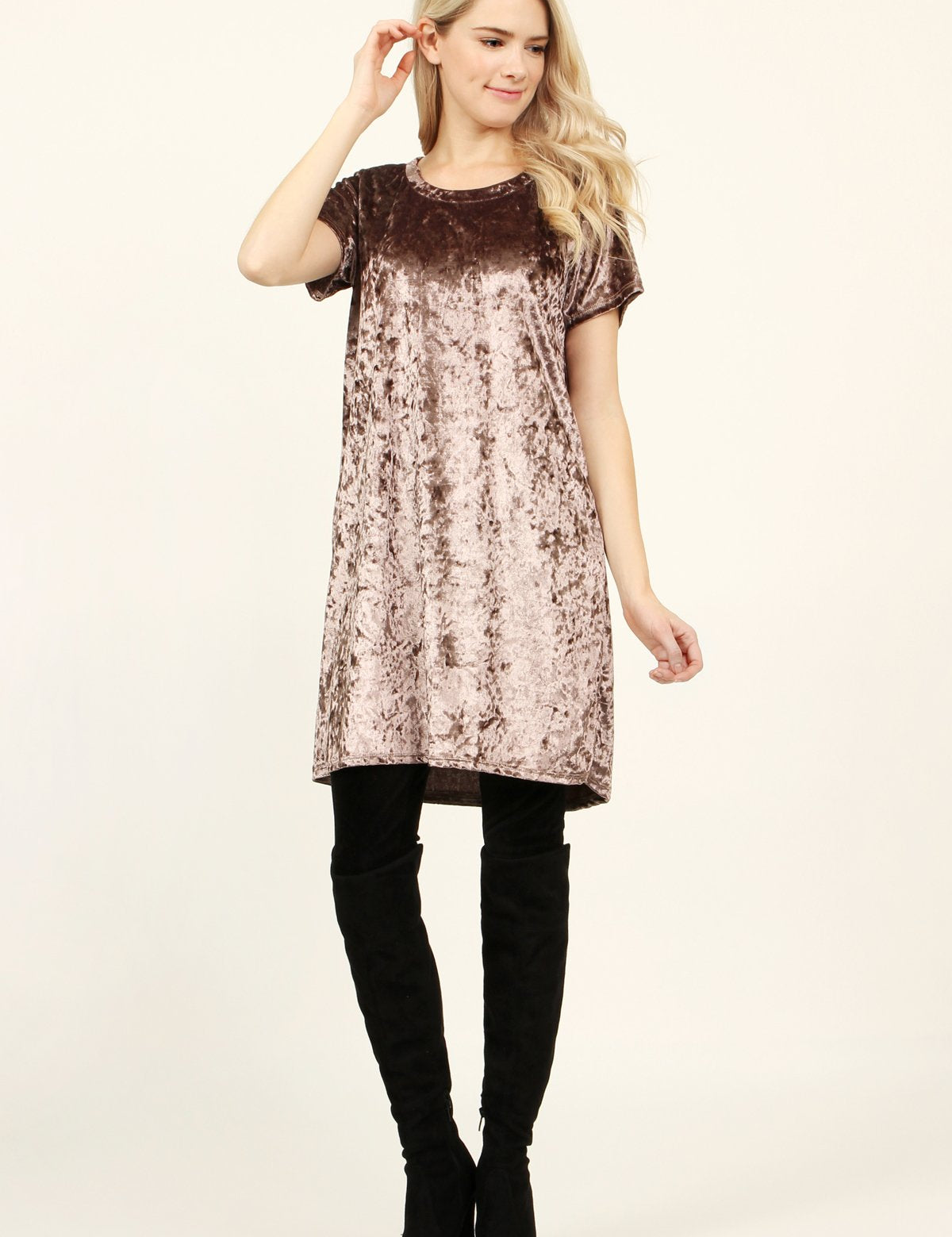 Woman wearing Calyn Crushed Velvet Tunic Dress in rose, styled with black over-the-knee boots, showcasing relaxed fit and luxe texture.