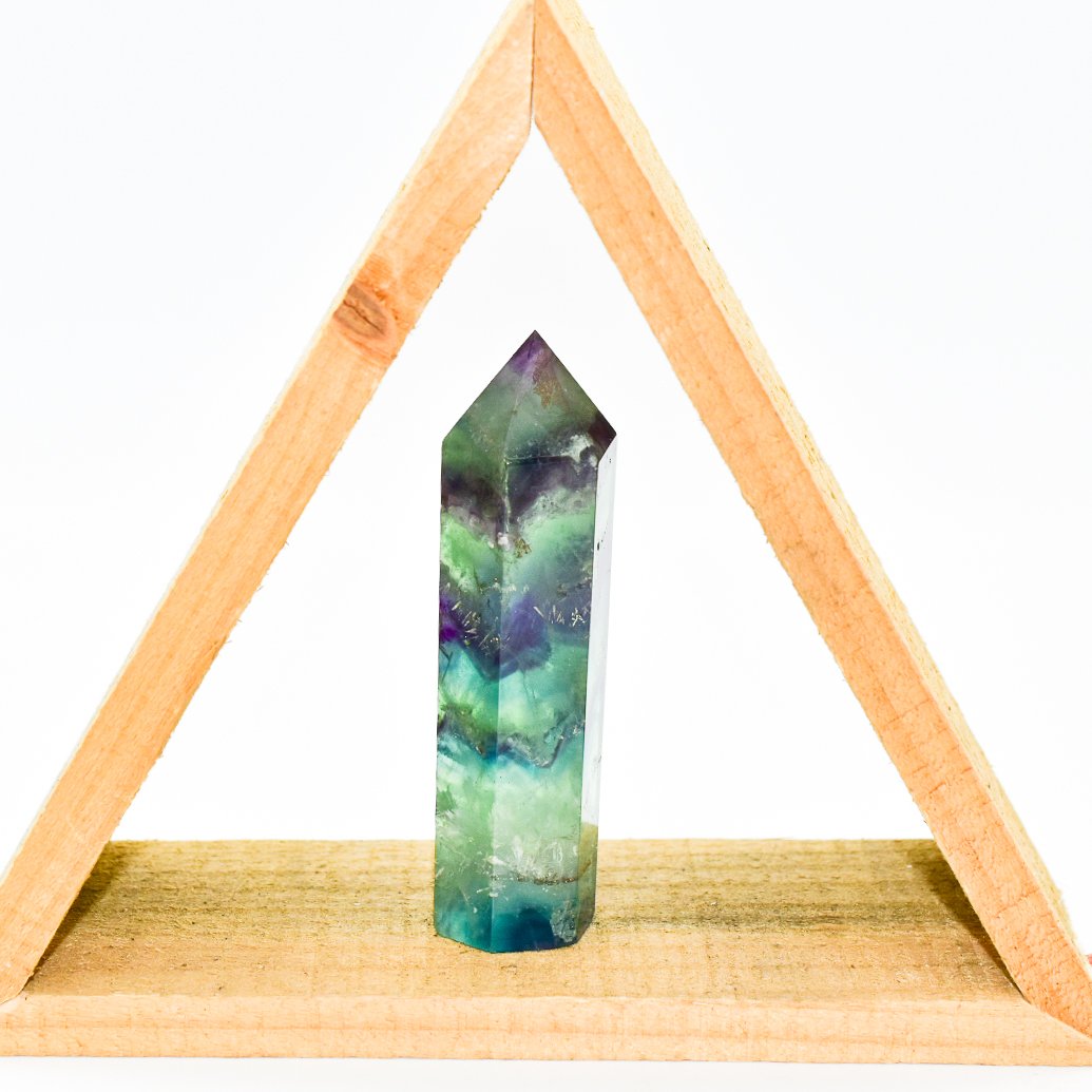 Auren Fluorite Energy Point, polished crystal for spiritual alignment and energy clearing, displayed within a wooden triangle shelf.
