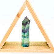 Auren Fluorite Energy Point, polished crystal for spiritual alignment and energy clearing, displayed within a wooden triangle shelf.