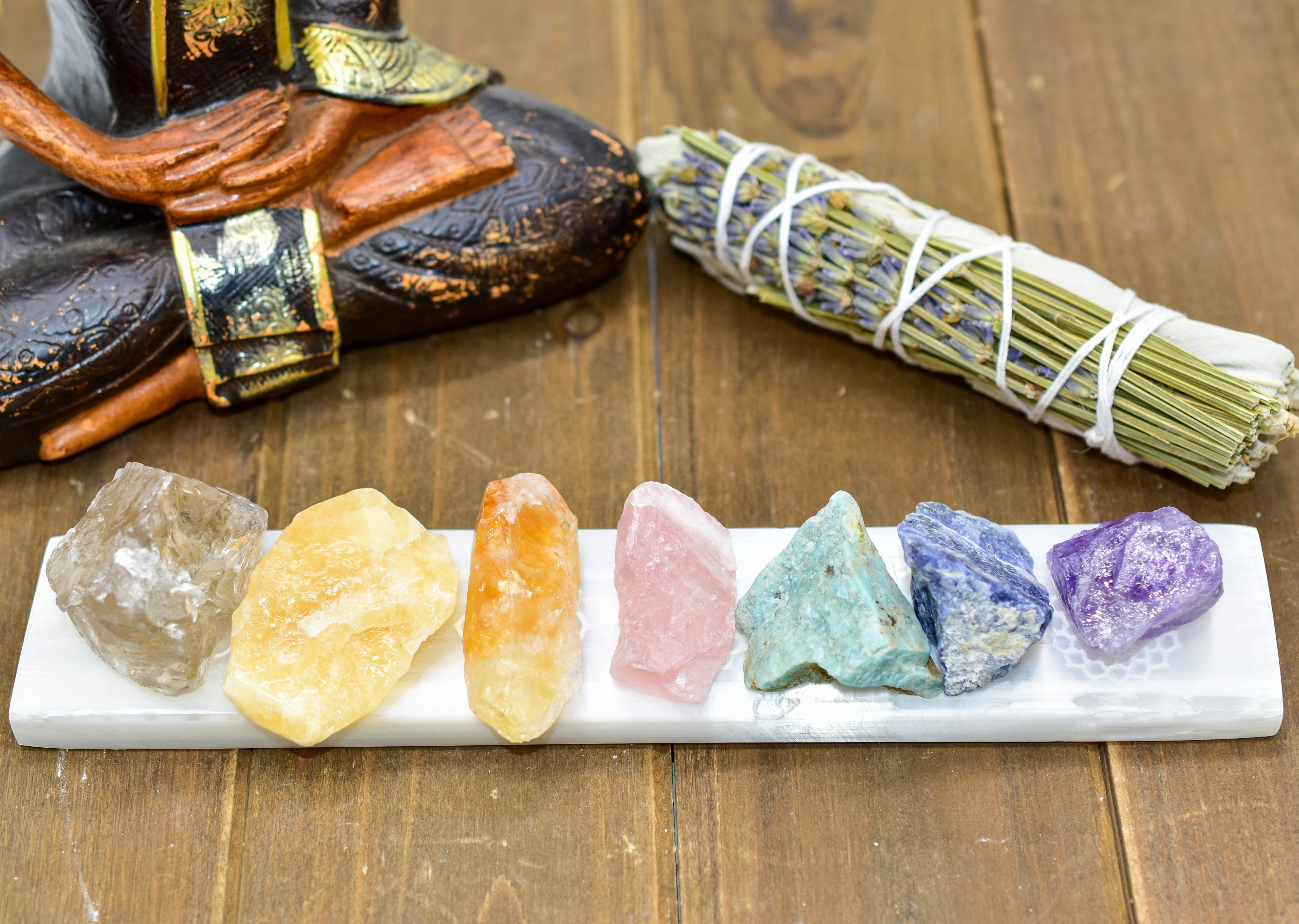 7 Chakra Selenite Charging Bar with crystals, featuring engraved symbols for energy balance and spiritual practice on a wooden surface.