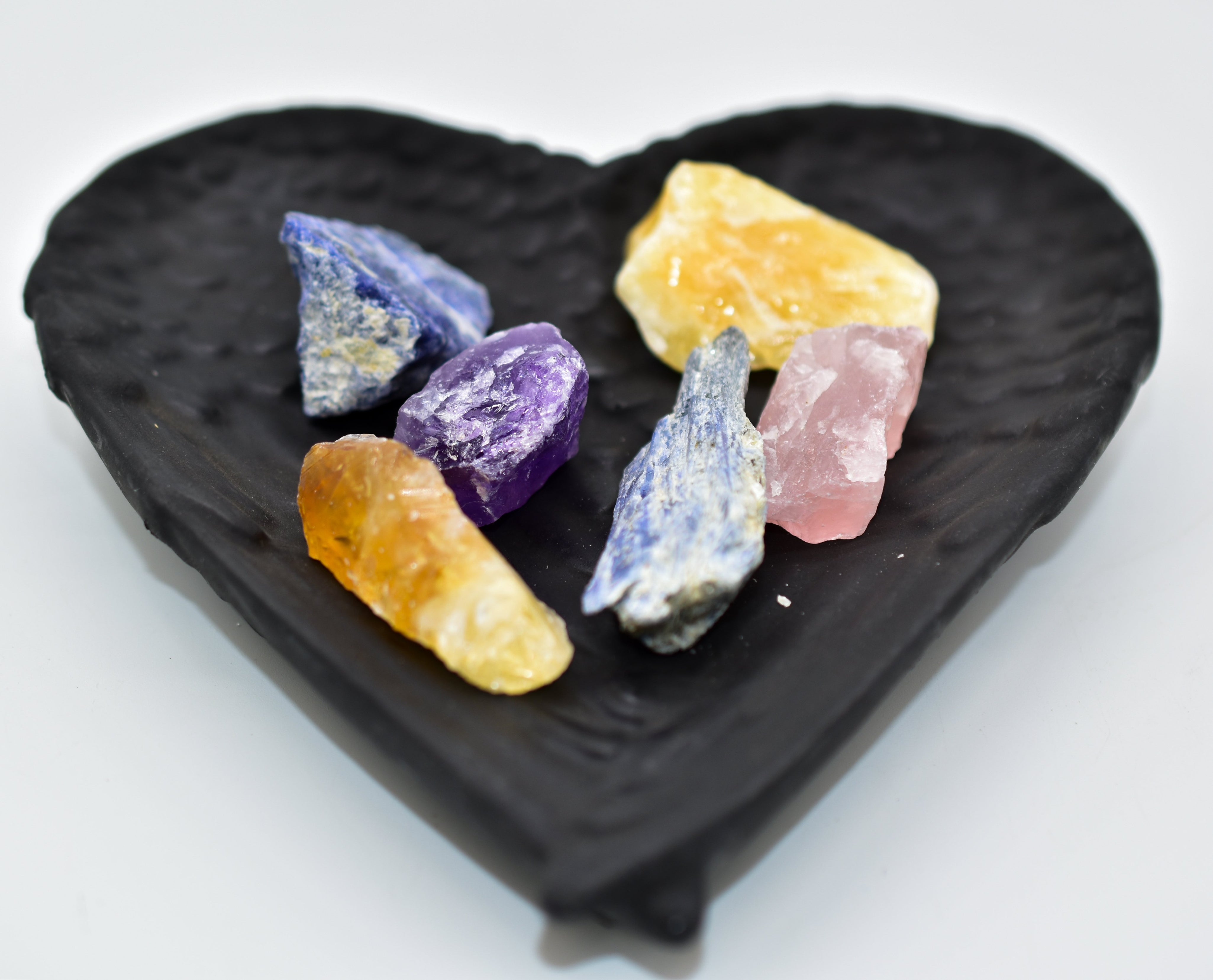 Shungite heart-shaped dish with colorful crystals, offering EMF protection and grounding energy.