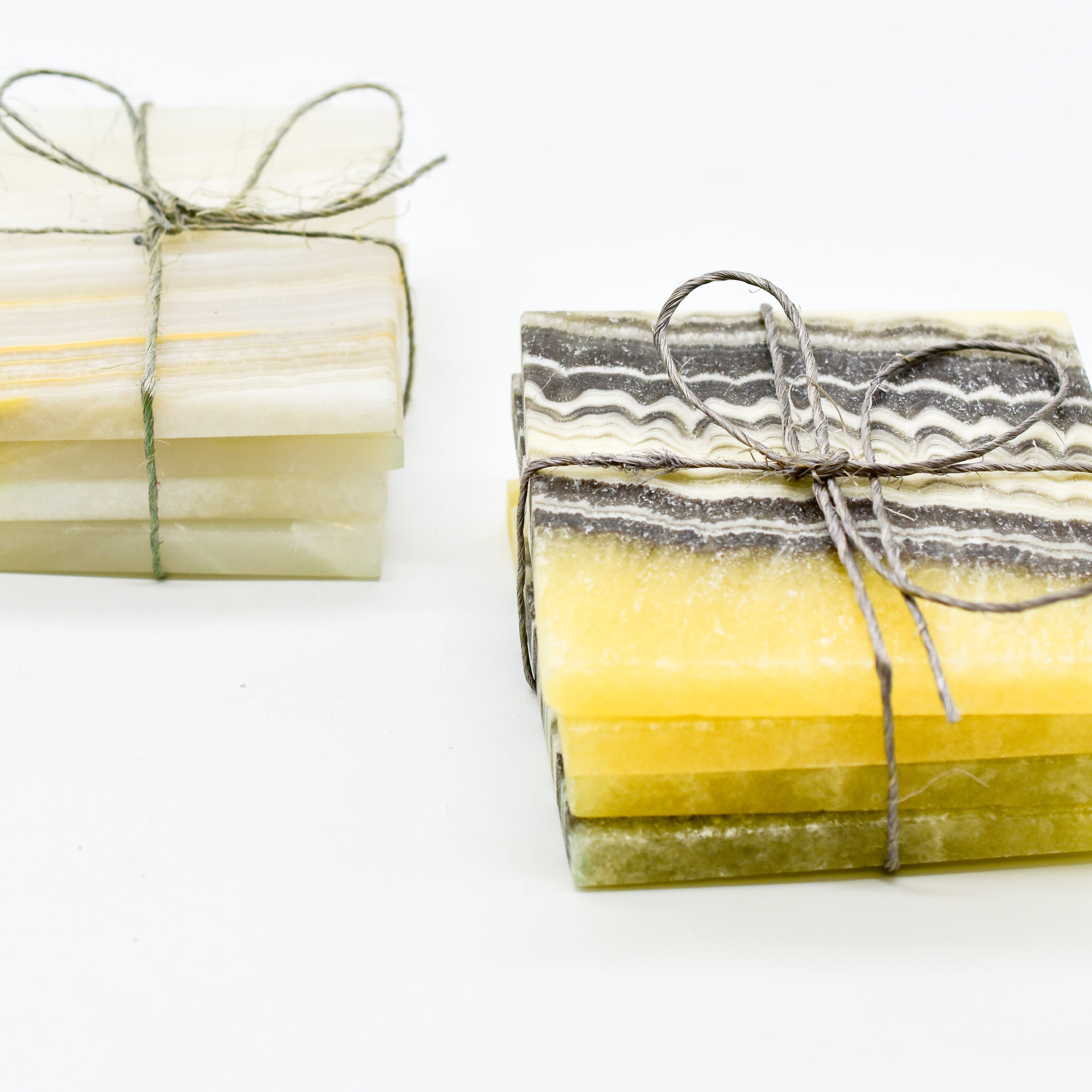 Luxurious Calvera handcrafted onyx coaster set of four, showcasing unique natural stone veining and color variations.
