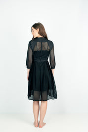 Woman wearing Lixell Mesh‑Panel Dress with sheer black mesh, showcasing elegant button back detail, perfect for evening wear.