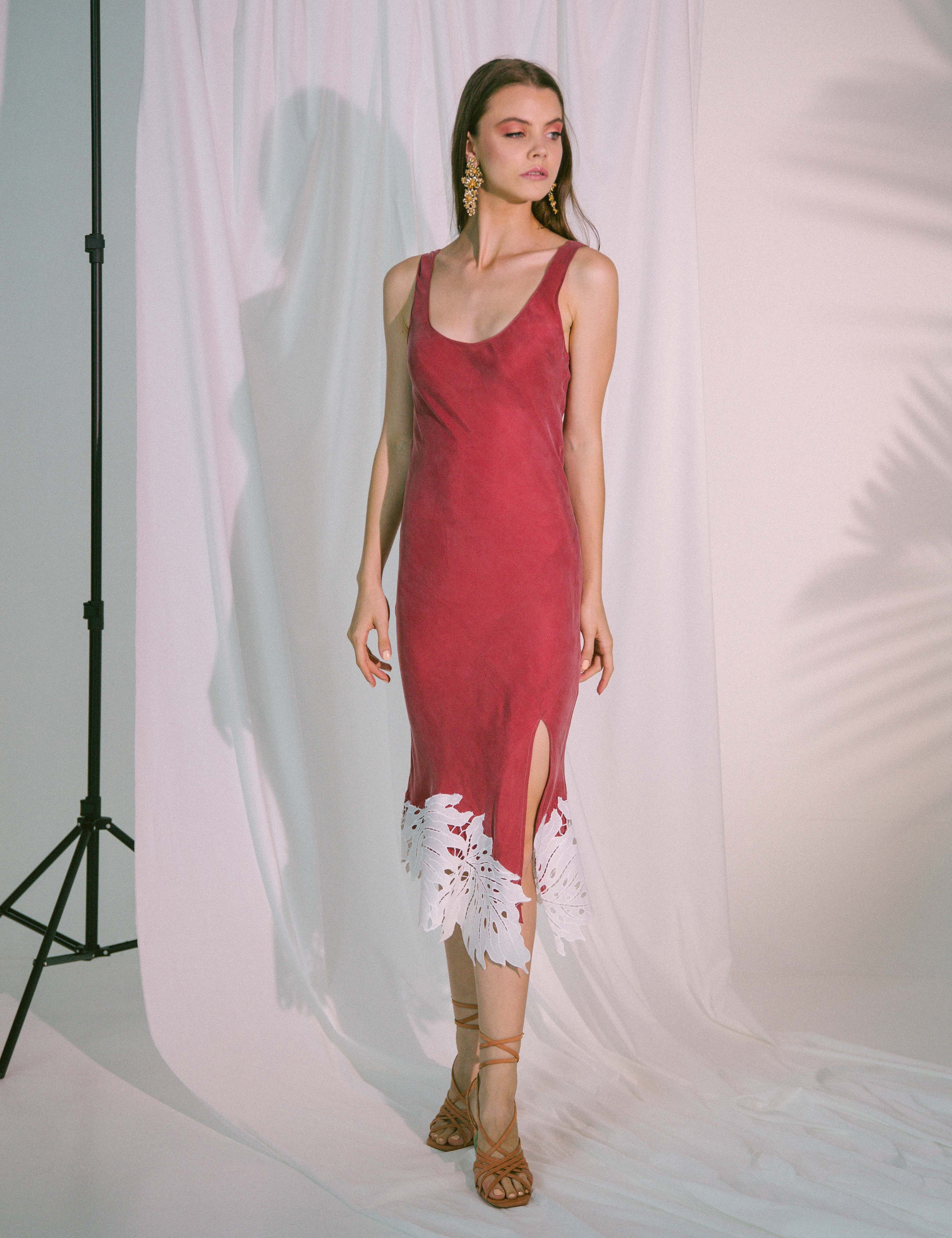 Woman wearing a Crimson Flow Bias-Cut Midi Dress with claret tone and cotton broderie hem, ideal for elegant evenings and garden parties.