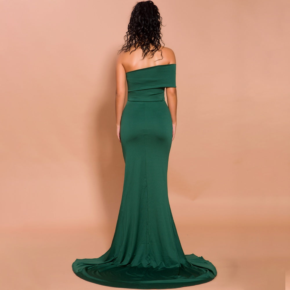 Back view of Sylvera deep green slit evening gown with off-shoulder design, floor-length skirt, and elegant silhouette for formal occasions.