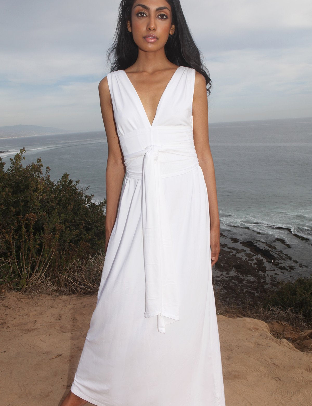 Woman wearing Sylvaya Organic Bamboo Maxi Dress by the ocean, showcasing its elegant and eco-friendly design.