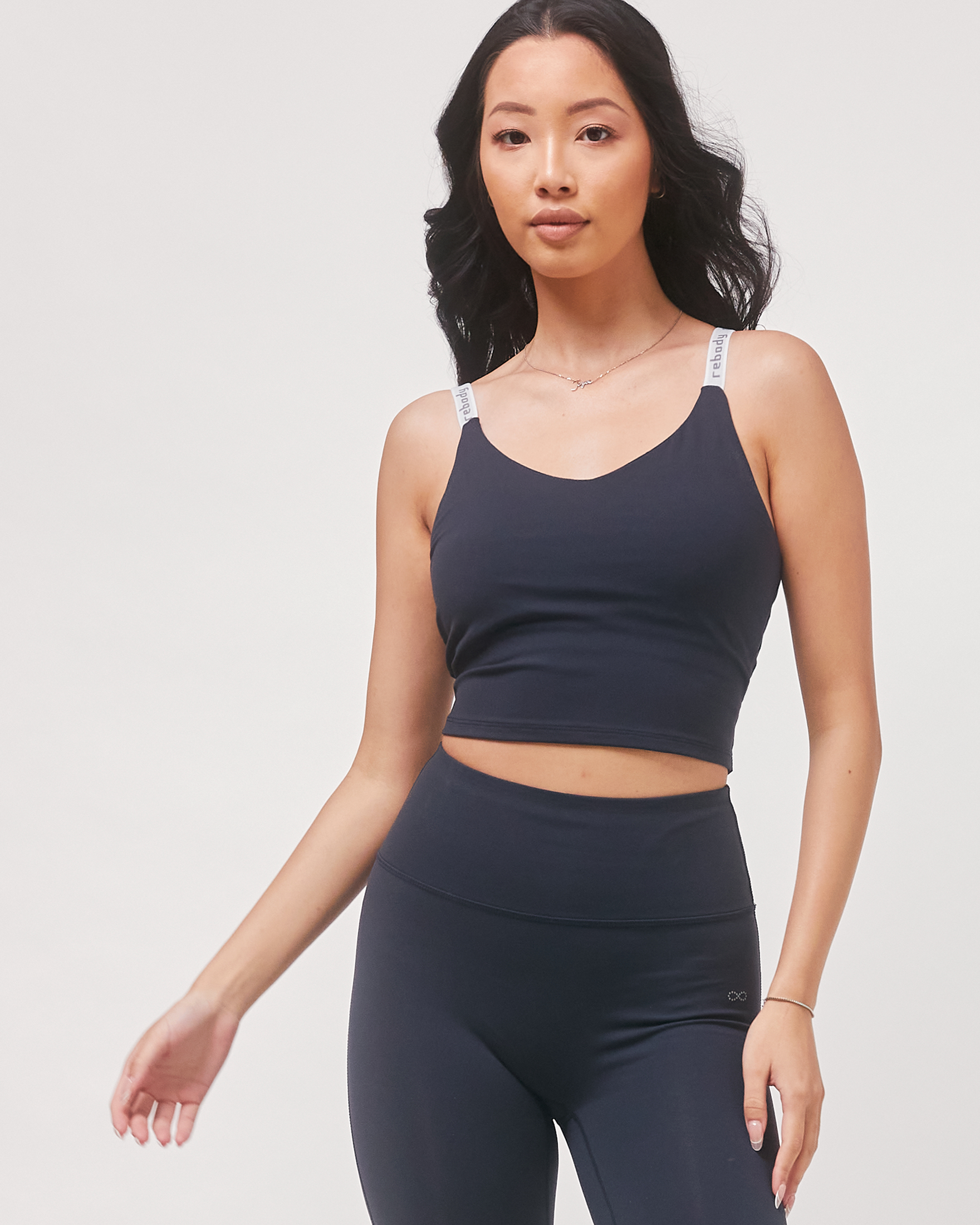 Woman wearing Irynelle Contour Bra Top, navy longline silhouette with scoop neckline, designed for yoga and urban elegance.