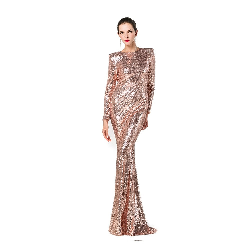 Elegant woman wearing a gold sequin open-back ball gown with long sleeves and a flowing skirt, perfect for glamorous events.
