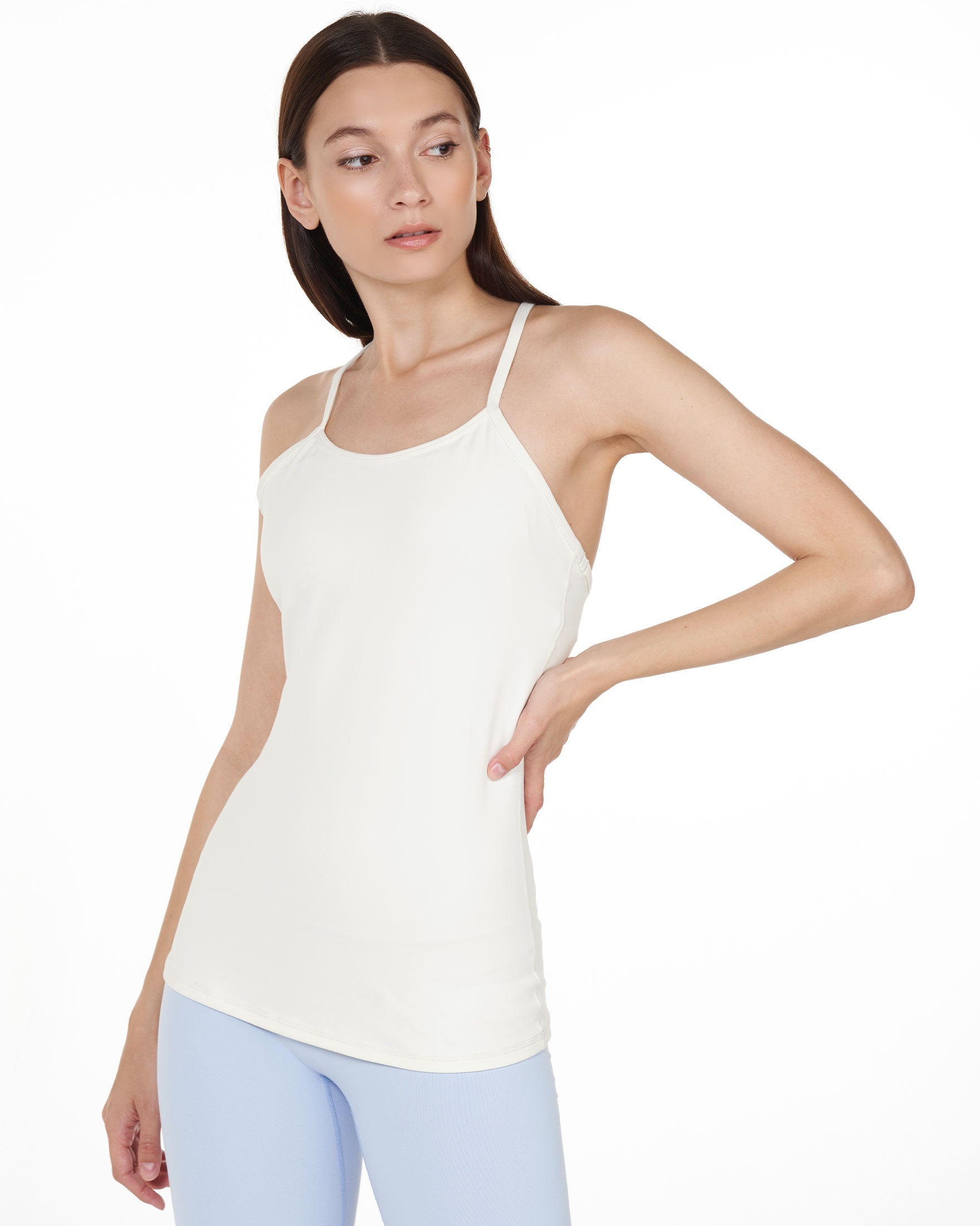 Woman wearing Calriena Motion Bra Tank in white, showcasing its sleek, supportive design, perfect for yoga and everyday wear.