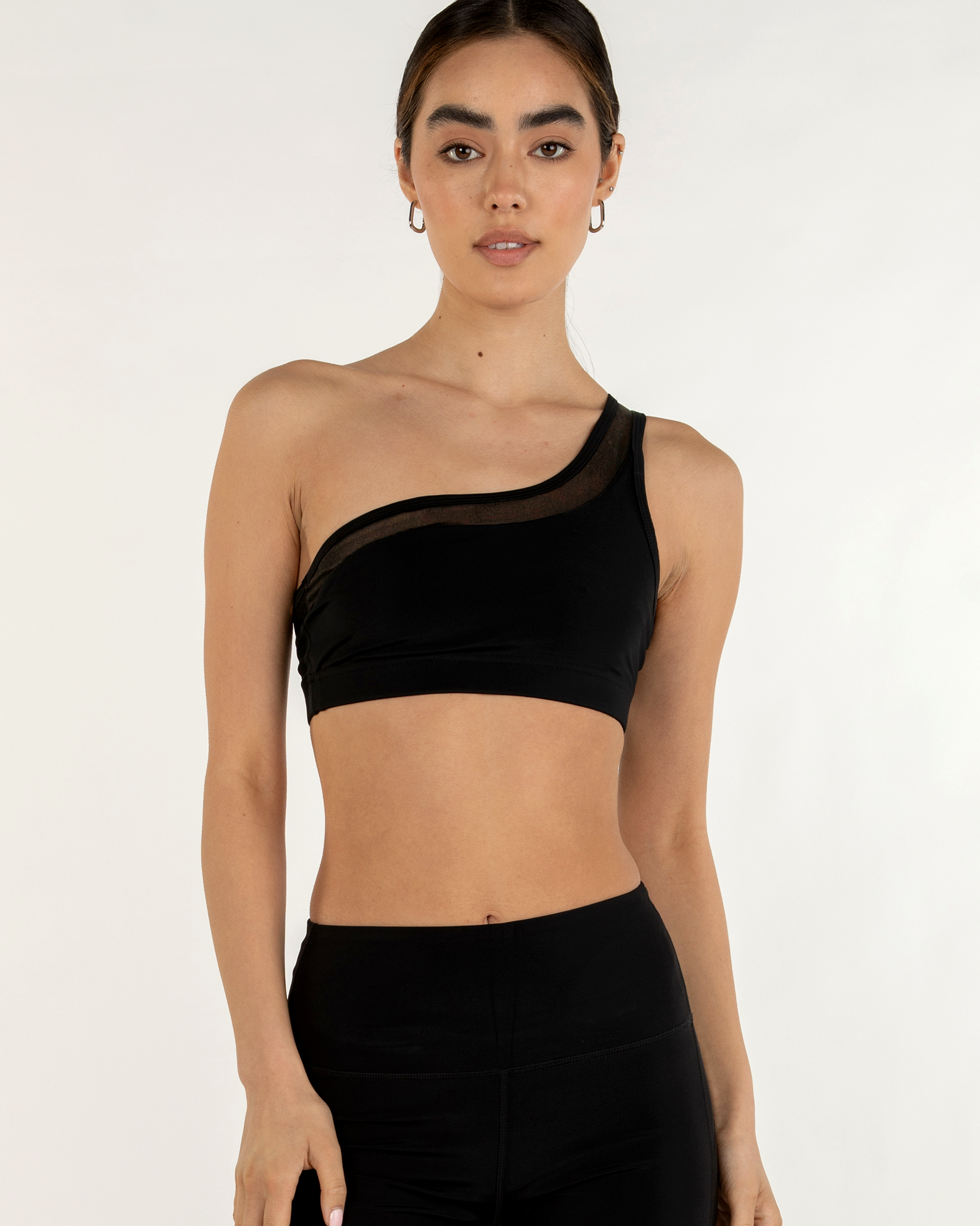 Narevia one-shoulder mesh bra in black featuring a sleek design with Silkiflex™ fabric, worn by a model in a studio setting.