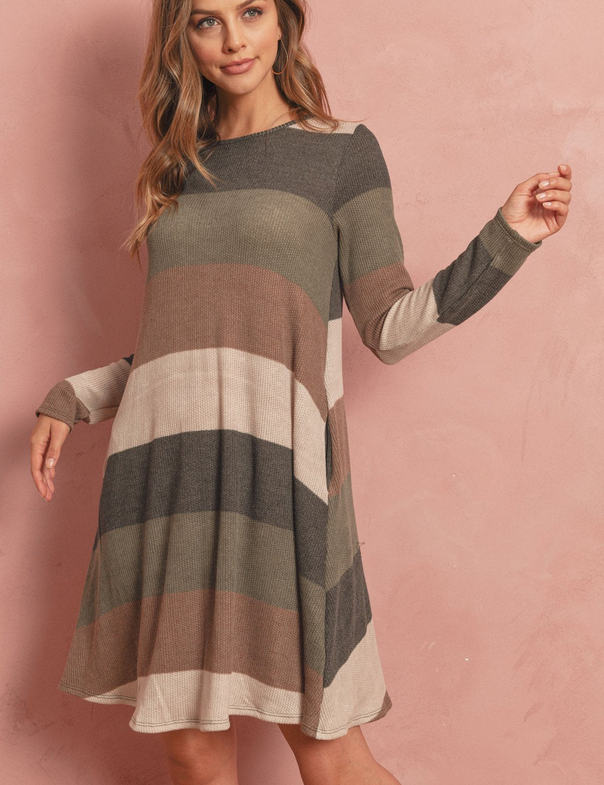 Solvia Ribbed Swing Pocket Dress with long sleeves, round neckline, ribbed texture, and side pockets in a striped pattern on a woman.