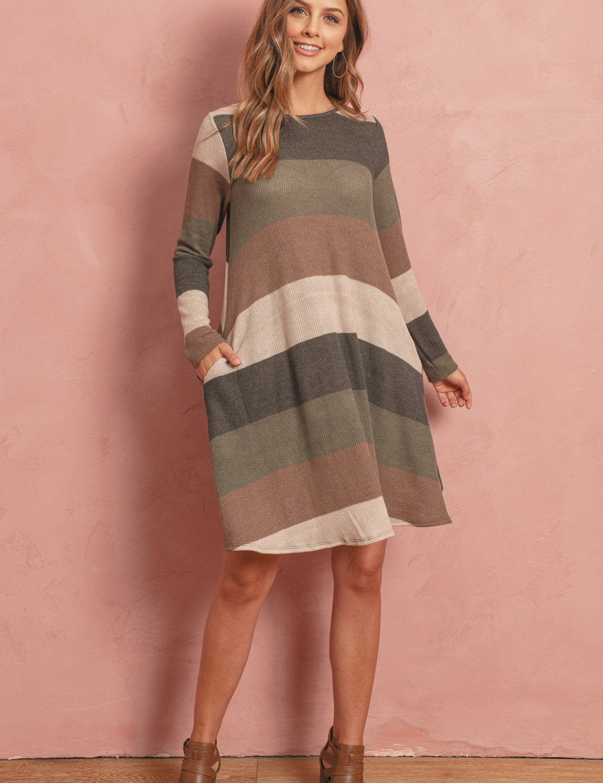 Solvia Ribbed Swing Pocket Dress with long sleeves, round neckline, and discreet side pockets, worn by woman with boots.