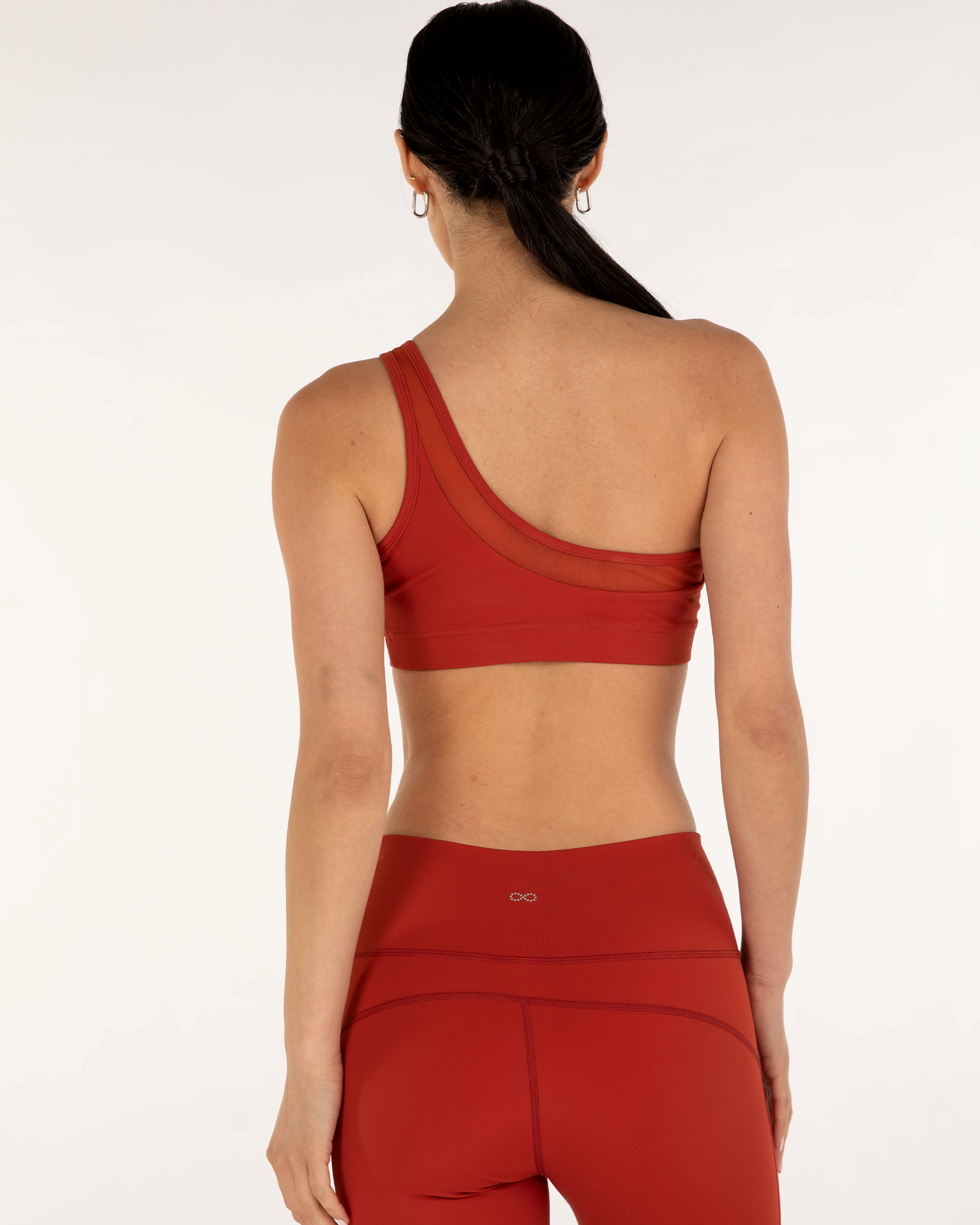 Back view of woman wearing Narevia One-Shoulder Mesh Bra in red with stylish design and supportive Silkiflex™ fabric.