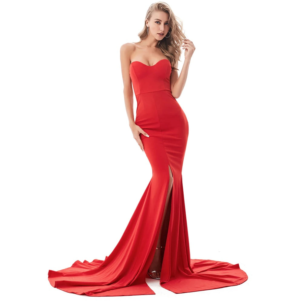 Woman wearing a red strapless mermaid gown with a fitted silhouette and flared hem, showcasing elegant evening wear.