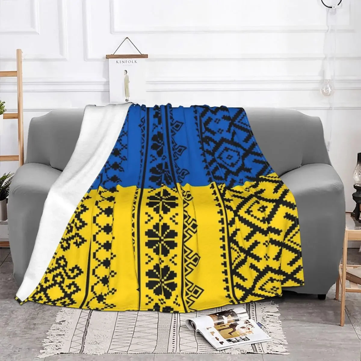 Luxurious flannel blanket with Ukrainian Vyshyvanka embroidery draped over a sofa, featuring blue and yellow ethnic patterns.