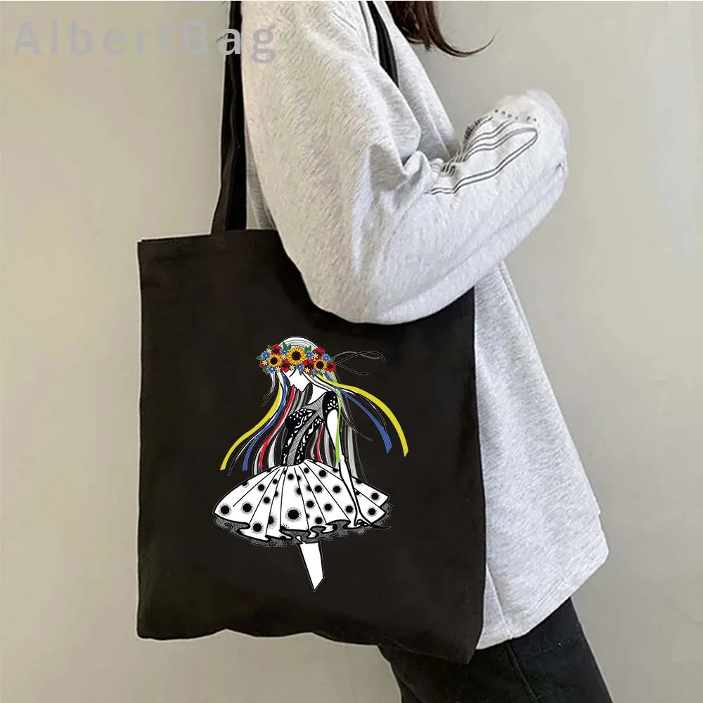 Black tote bag with a Ukrainian patriotic print design, showcasing colorful ribbons on a stylish black and white dress.