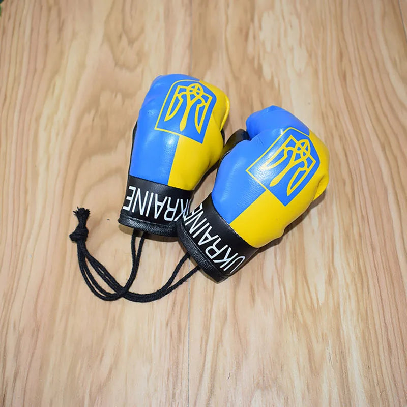 Ukraine flag boxing gloves keychains with vibrant yellow and blue design on wood surface. Perfect for showing national pride.