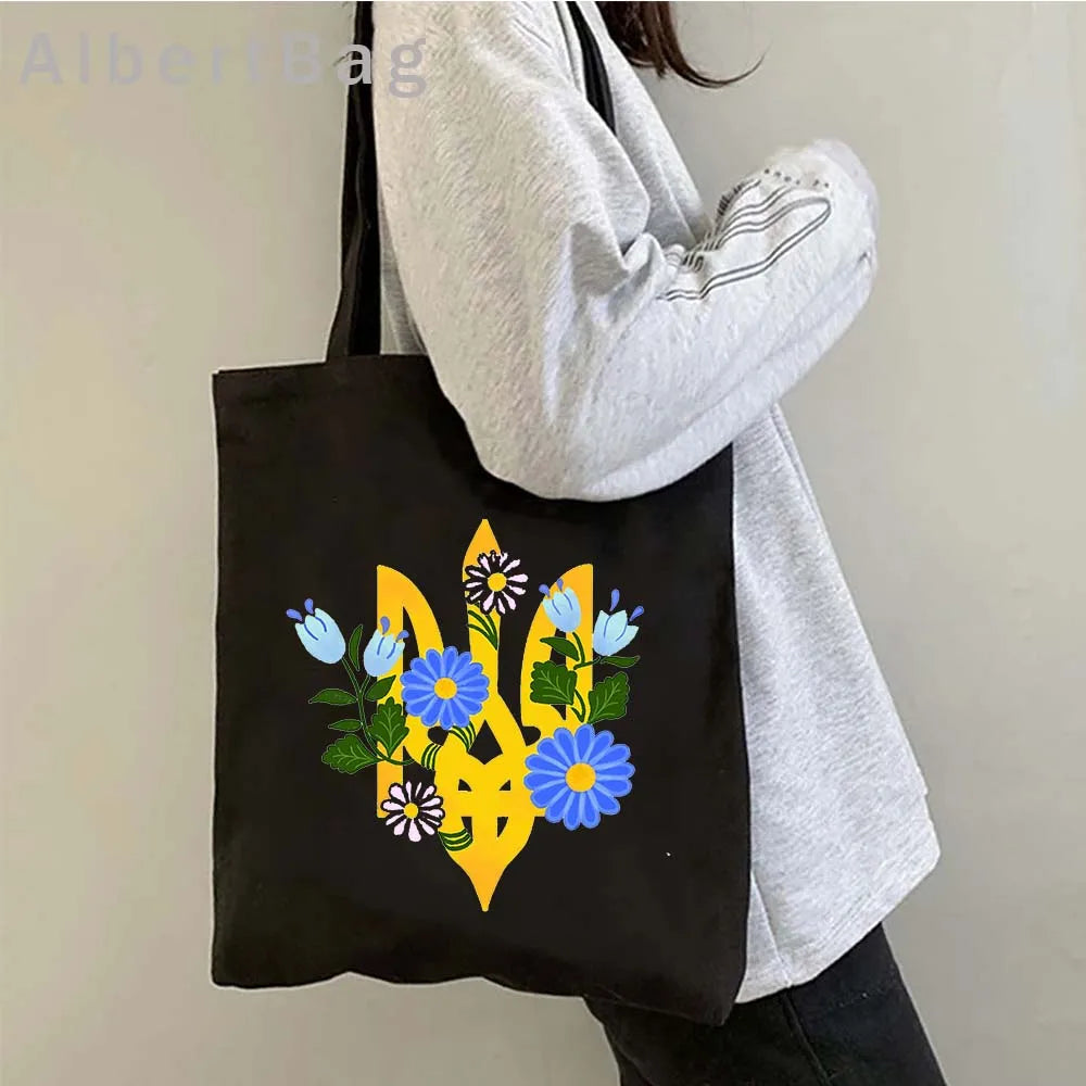 Ukrainian Patriotic Grocery Tote Bag with floral design being carried by person in casual outfit. Eco-friendly cotton reusable shopping bag.