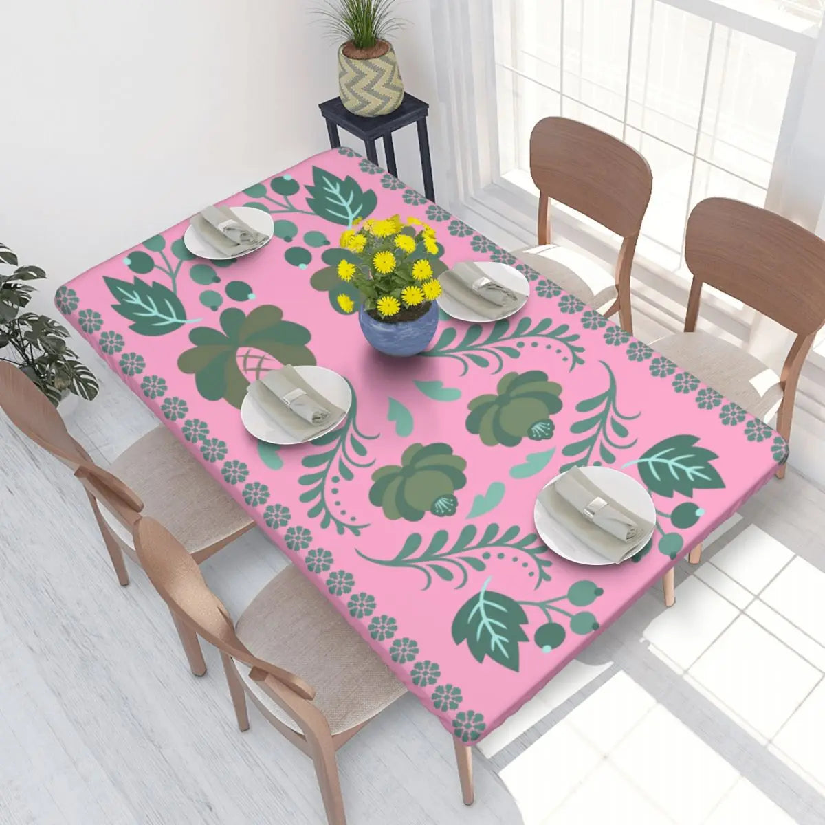 Pink Ukrainian embroidery table cover with green floral pattern enhancing dining decor.