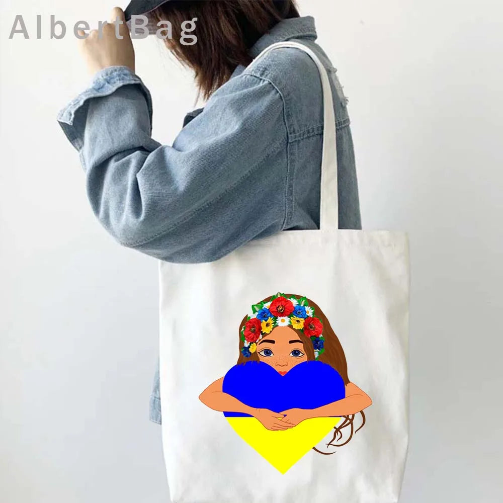 Woman carrying Ukrainian patriotic grocery tote bag with floral design and flag colors.