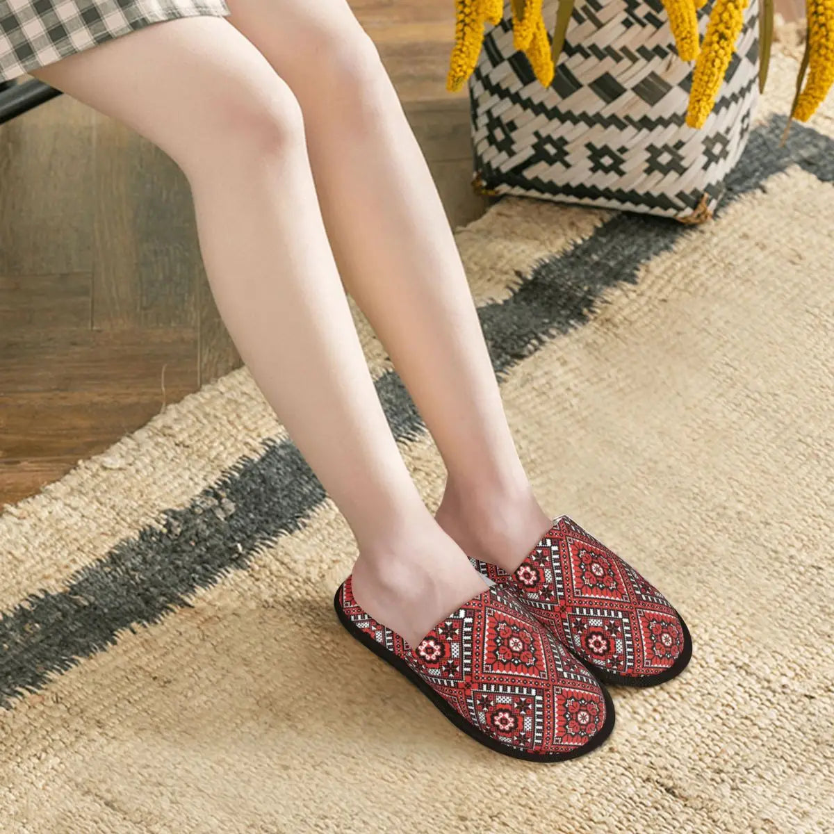 Ukrainian embroidery ornament slippers with intricate design and red pattern on a woven rug.