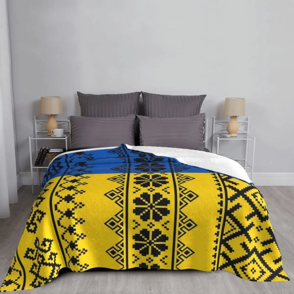 Ukrainian Vyshyvanka flannel blanket on bed, featuring yellow and blue embroidery, perfect for cozy comfort and ethnic charm.