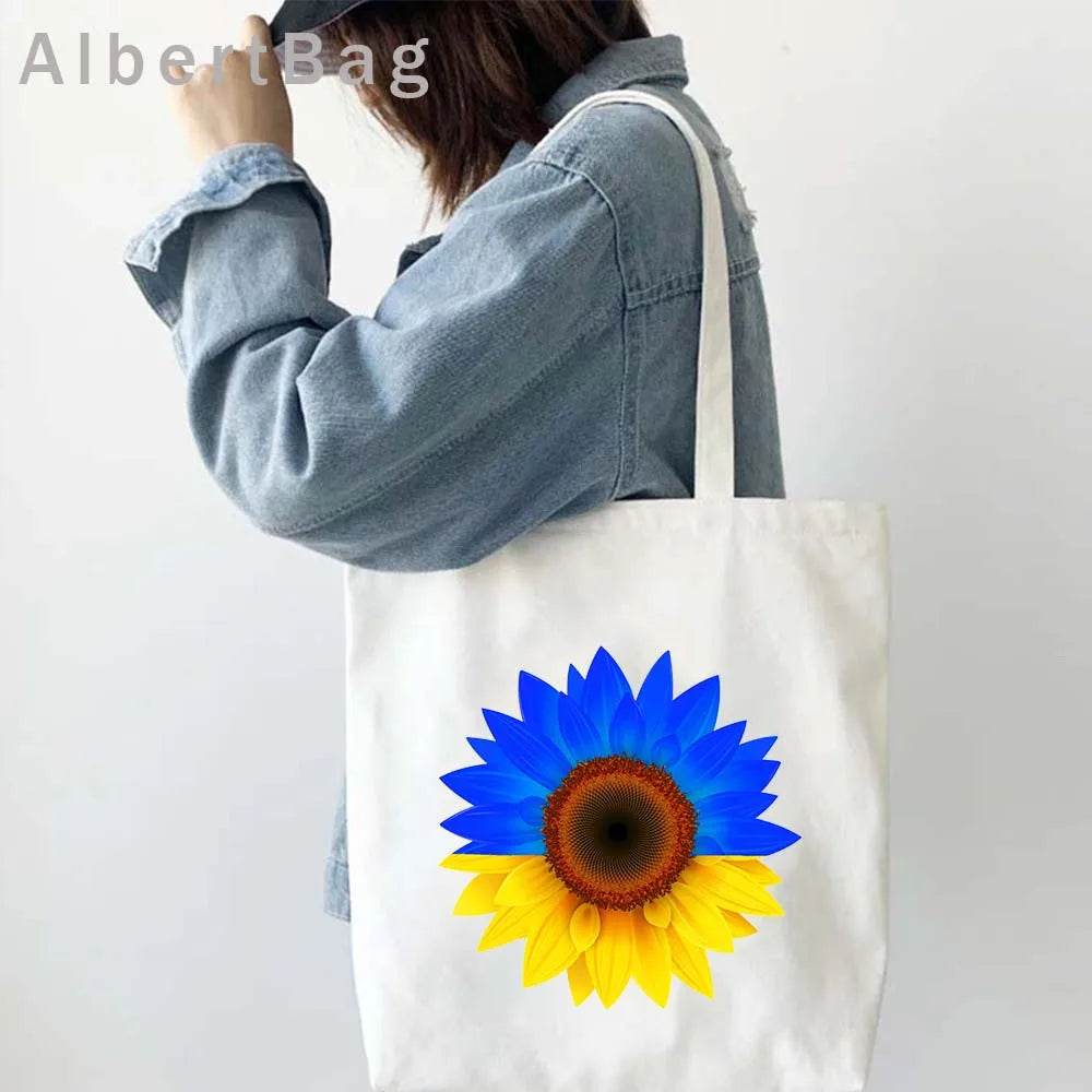 Woman carrying Ukrainian Patriotic Grocery Tote Bag with sunflower design, eco-friendly reusable cotton fabric.