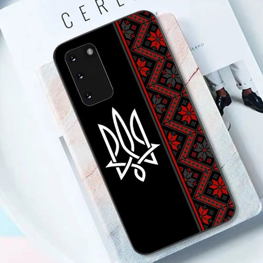 Ukrainian Tryzub Samsung phone case with black TPU material and traditional red pattern design, shown on a table surface.