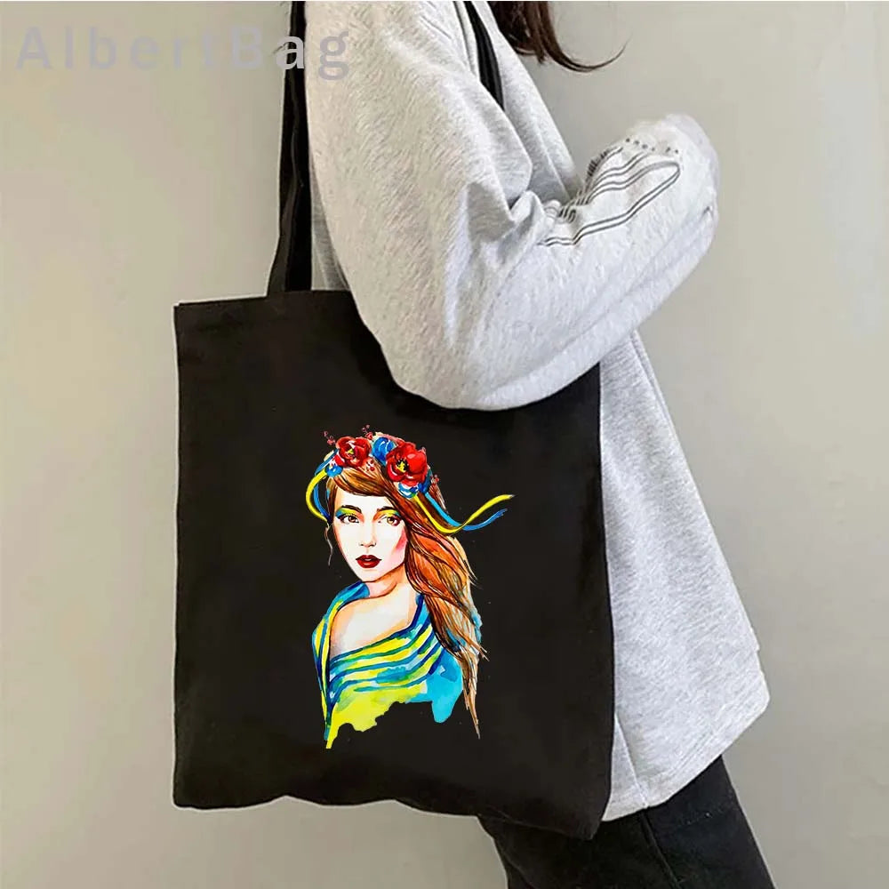 Ukrainian Patriotic Grocery Tote Bag with colorful portrait design, eco-friendly cotton, worn by person in gray sweater