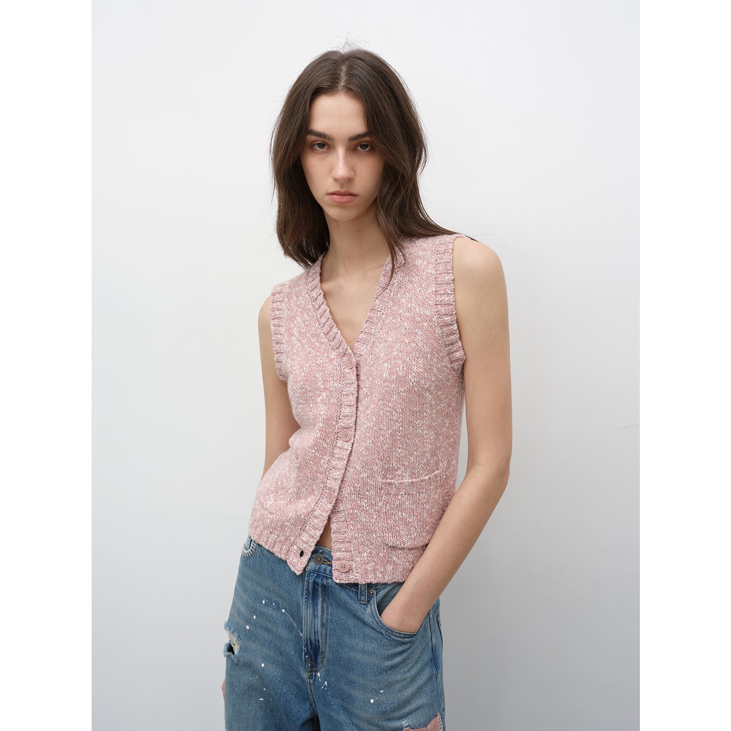 Model wearing Ferwynn Dotted Merino Vest in pink, showcasing V-neck design, color-block texture, and elegant urban style.