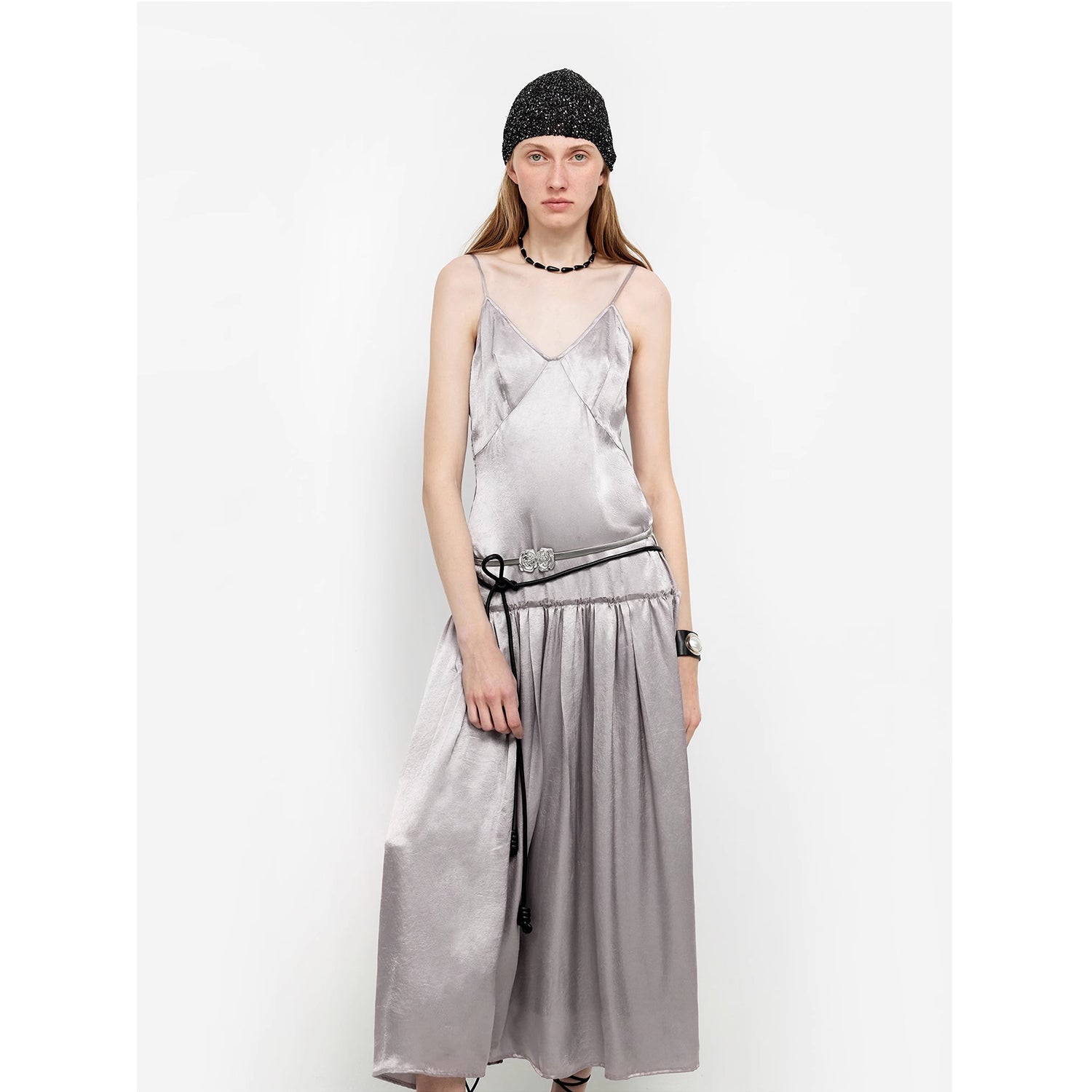 Elegant woman wearing a Lowline Luxe Satin Dress with a V-neck, low-waist, and adjustable straps, showcasing modern minimalist style.