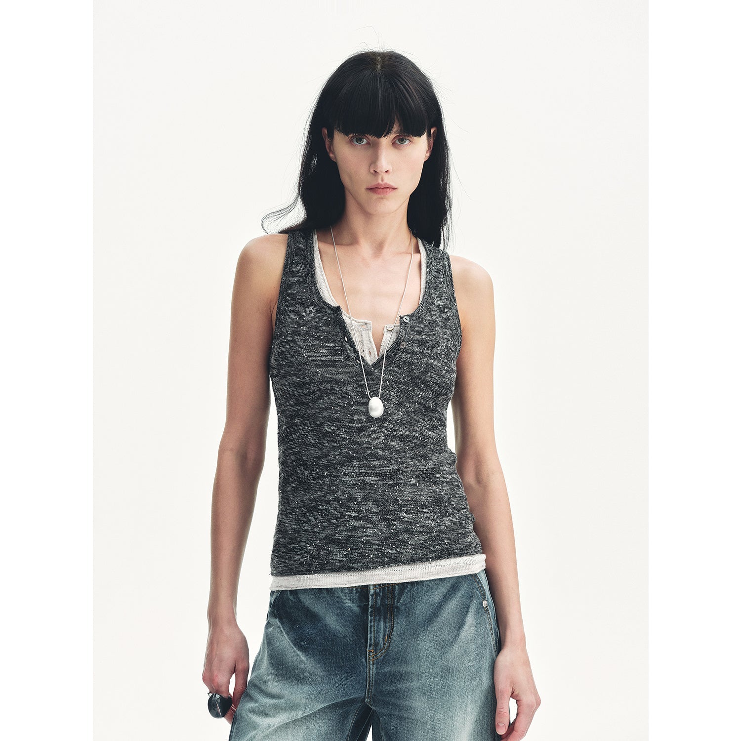 Woman wearing Meredelle Sequin Henley Vest with gradient sequins and Henley neckline, styled with casual jeans.