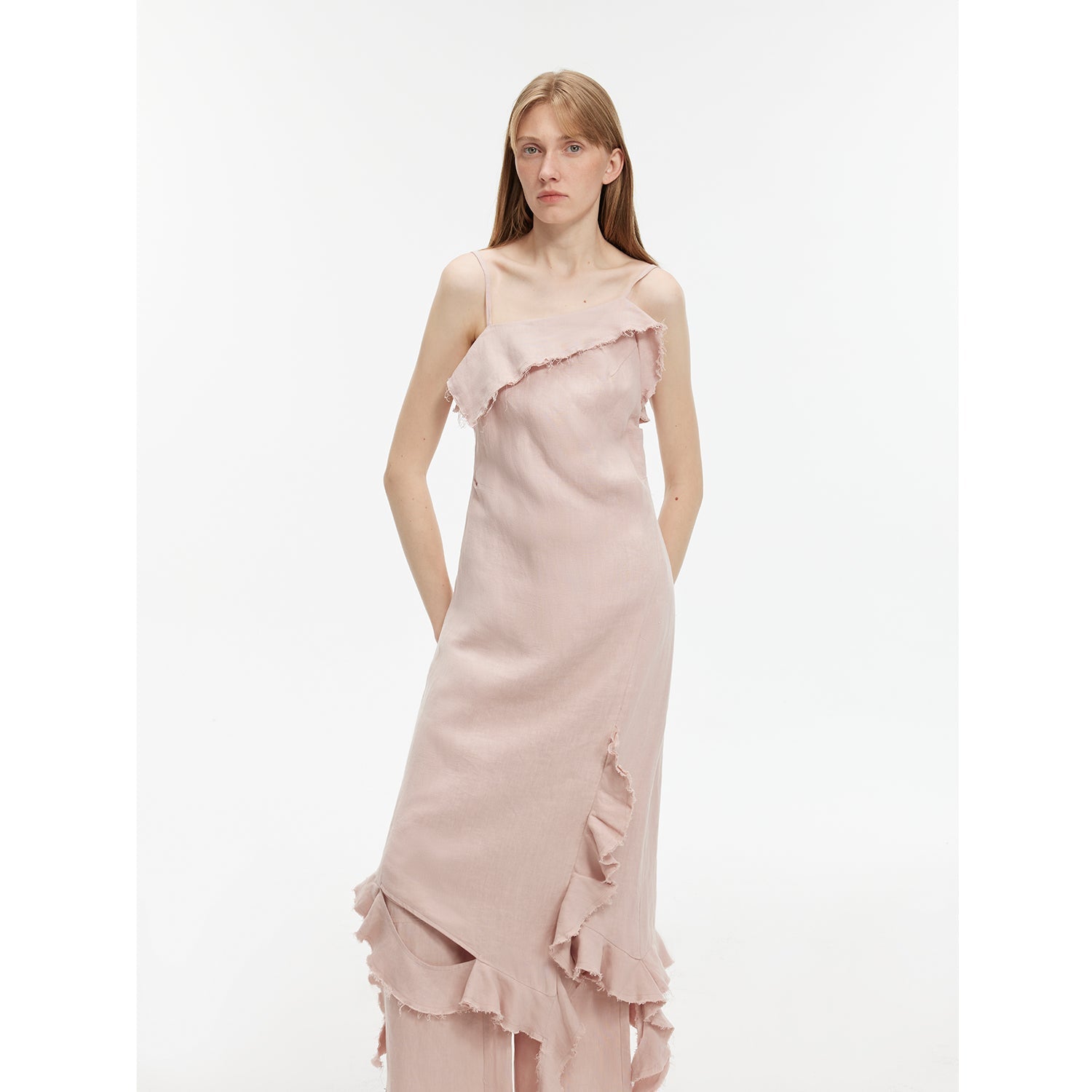 Model wearing Elanys Sand-Washed Linen Ruffle Dress with asymmetric neckline and pleated waist in light pink.