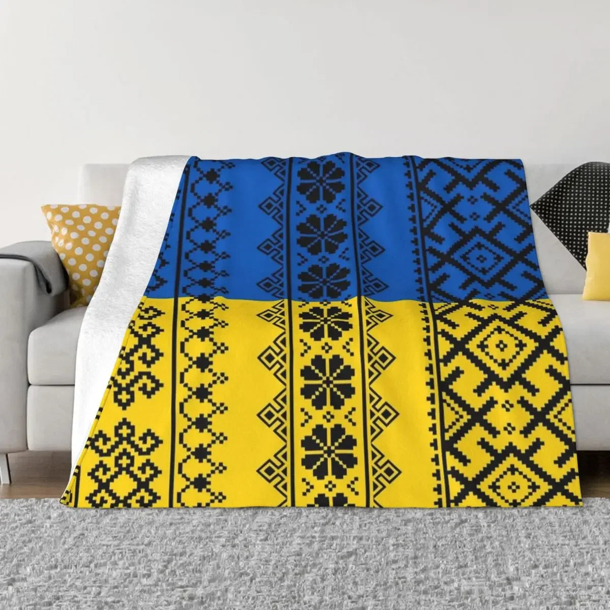 Ukrainian Vyshyvanka flannel blanket with blue and yellow embroidery draped over a sofa.