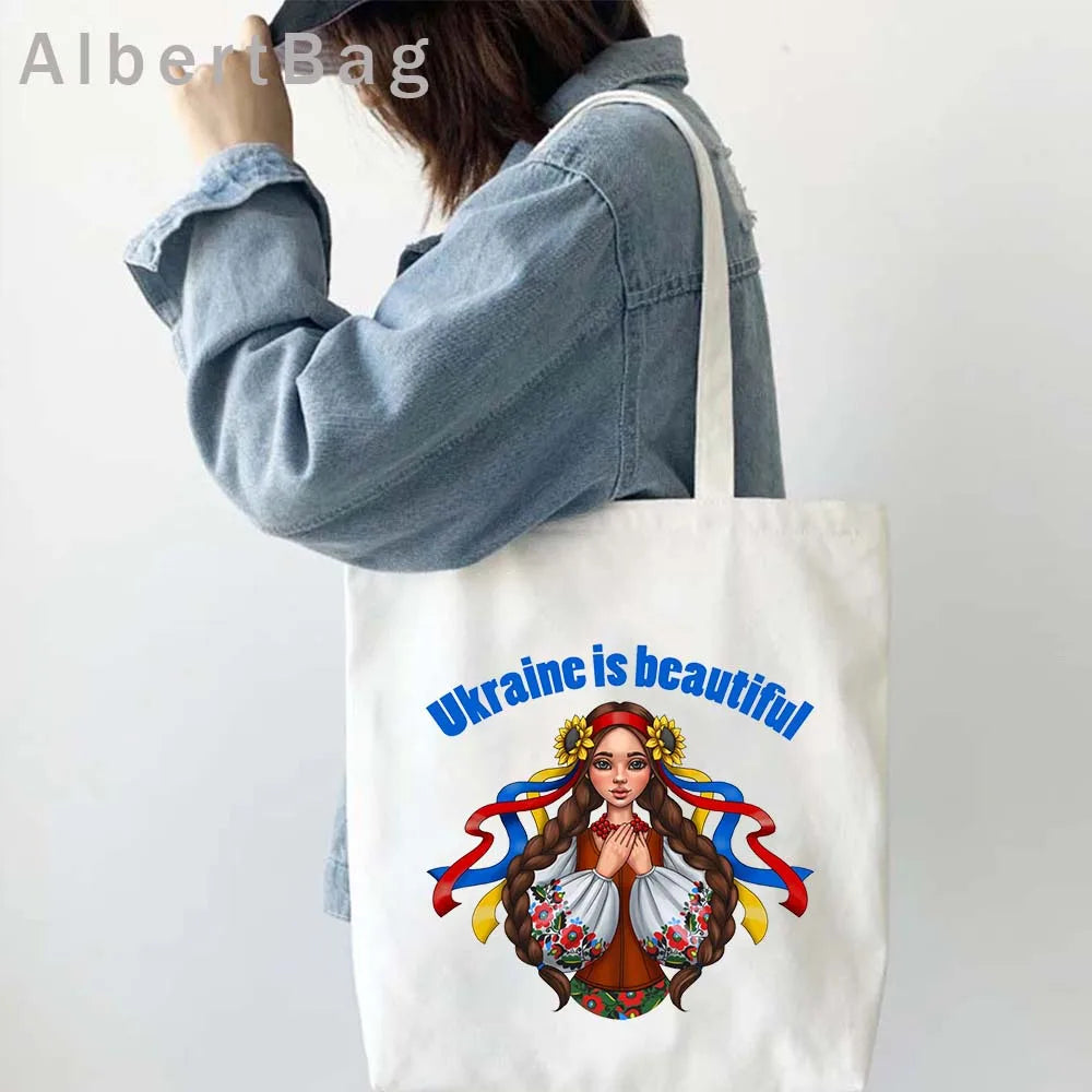 Woman carrying Ukrainian Patriotic Grocery Tote Bag with colorful design and text "Ukraine is beautiful".