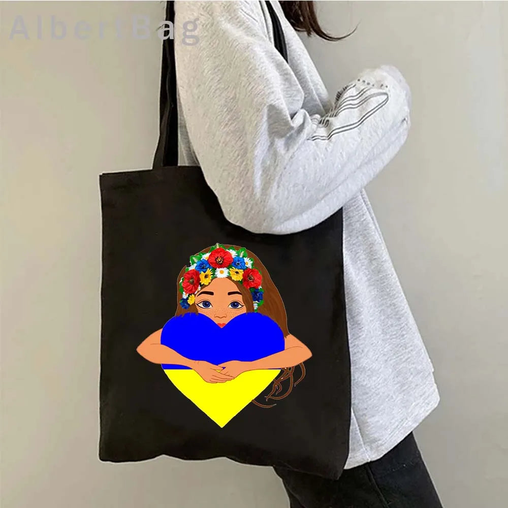 Ukrainian patriotic grocery tote bag with floral print design worn over shoulder.