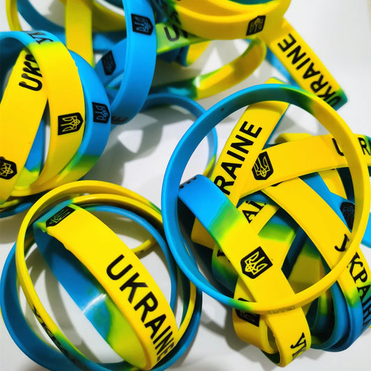 Ukrainian flag silicone bracelets in yellow and blue, featuring trident symbols and "Ukraine" text, showcasing national pride.