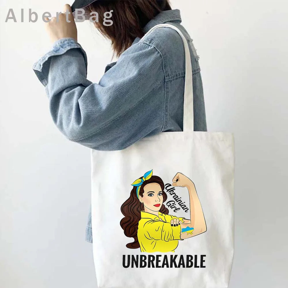 Woman carrying Ukrainian Patriotic Grocery Tote Bag with "Unbreakable" design in vibrant colors