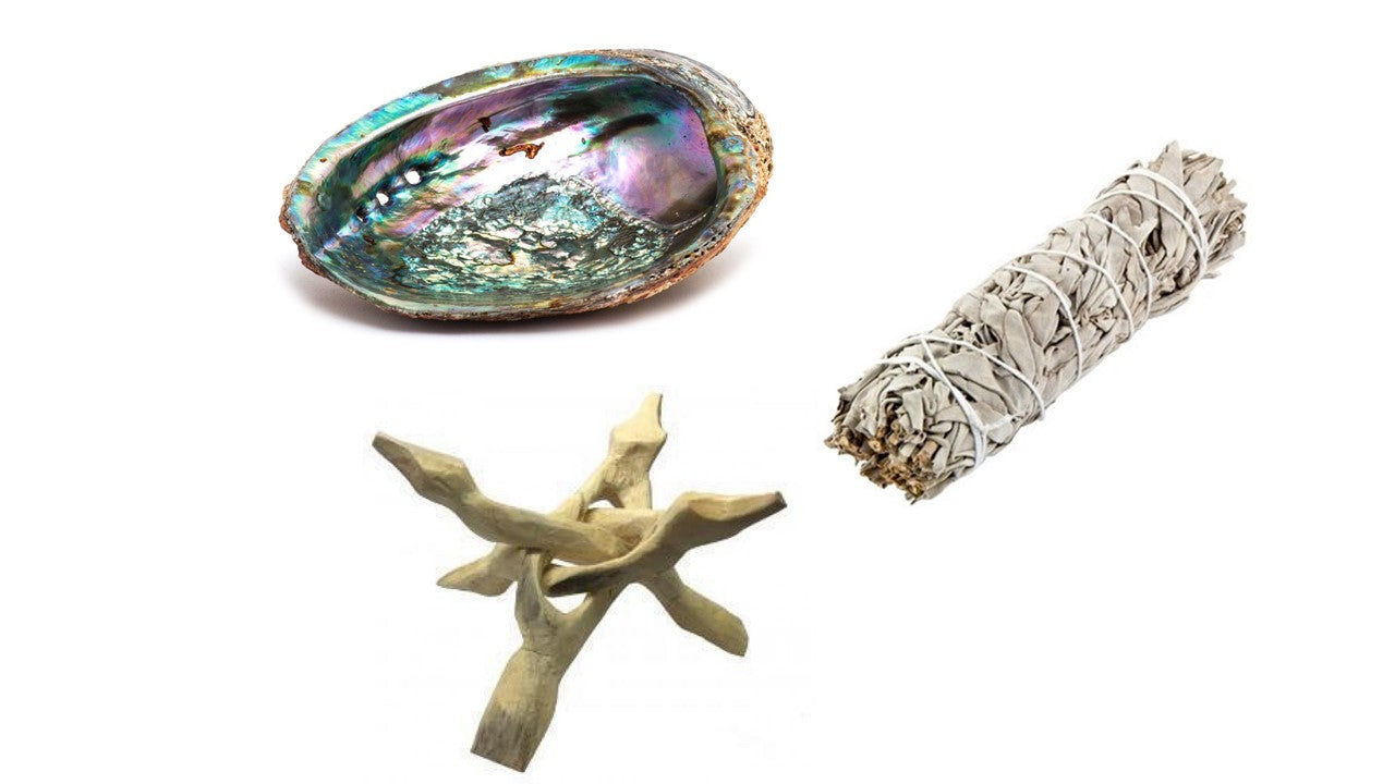 Abalone shell smudging set with iridescent shell, white sage stick, and wooden tripod stand for meditation and rituals.