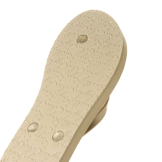 Textured sole of Nomad rhinestone flat flip flops sandal, featuring 'Sandal' embossed pattern, close-up view.