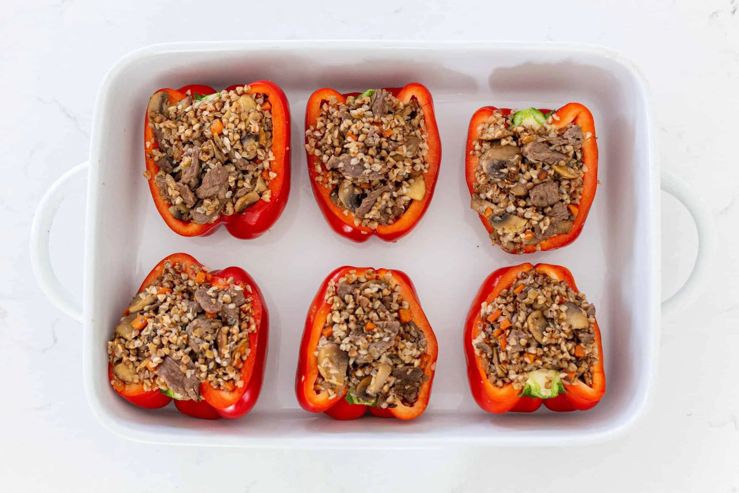 Tray of homemade Ukrainian stuffed peppers filled with rice and meat, showcasing a traditional and authentic dish. Perfect for hearty meals.