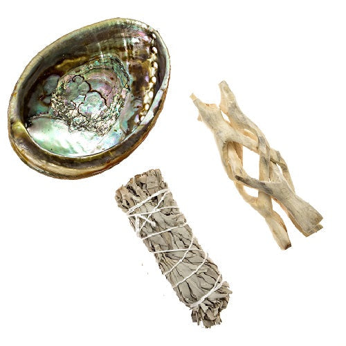 Abalone shell smudging set with white sage stick and wooden tripod stand for spiritual rituals and meditation.
