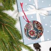 Ukrainian acrylic ornament with floral design on a blue polka dot gift box, adorned with a white ribbon and pine branches.